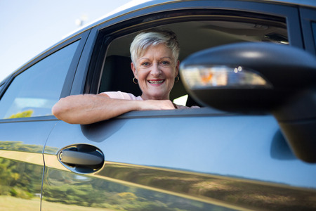 Portrait of active senior woman driving a car