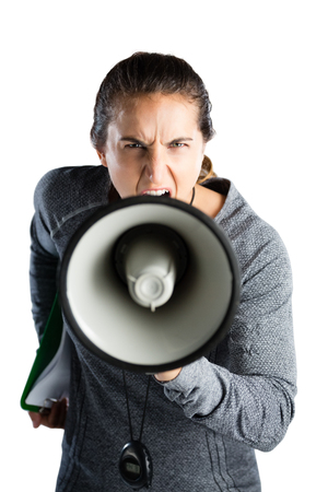 Portrait of female coach announcing on megaphone while standing against white backgroundの写真素材
