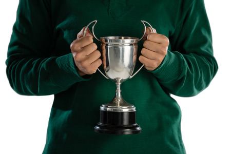 Mid section of female rugby player holding trophy while standing against white backgroundの写真素材
