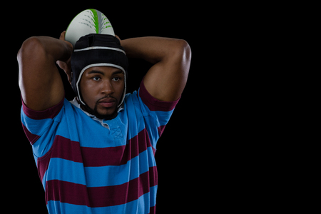 Sportsman wearing helmet while playing rugby against black backgroundの写真素材