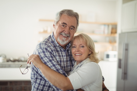 Portrait of senior couple embracing at home