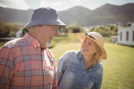 Smiling couple interacting with each other in garden on a sunny day