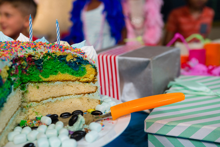Close up of birthday cake on table with children in backgroundの写真素材