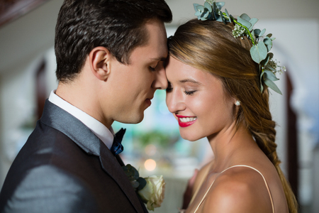 Smiling wedding couple standing face to faceの写真素材