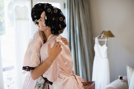 Smiling women embracing each other at homeの写真素材