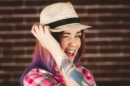 Portrait of smiling woman posing against brick wallの写真素材