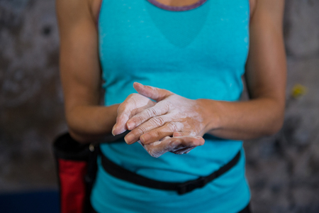 Mid section of woman rubbing powder on hands in fitness studioの写真素材