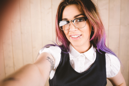Woman taking a selfie against wooden backgroundの写真素材