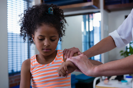 Physiotherapist giving hand massage to a girl in clinicの写真素材
