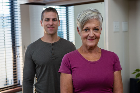 Portrait of smiling senior woman and physiotherapist in clinicの写真素材