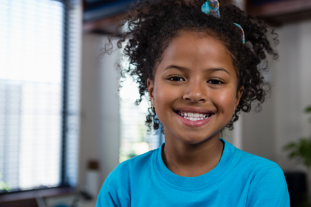 Portrait of smiling girl sitting on bed in clinicの写真素材