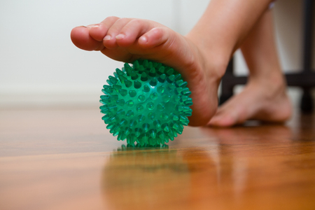 Low section of girl exercising with stress ball in hospitalの写真素材
