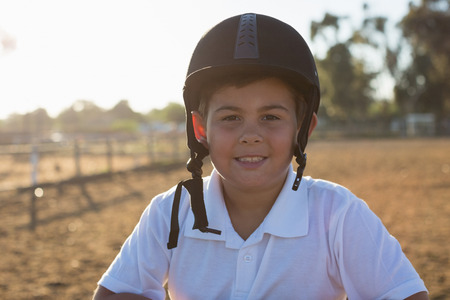 Boy smiling at camera in the ranch on a sunny day
