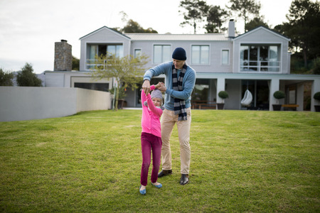 Happy father and daughter dancing in the gardenの写真素材