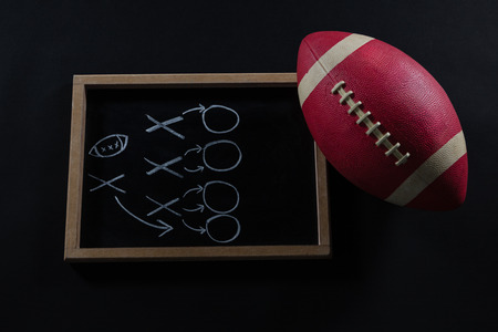 Close-up of American football and game strategy drawn on board against black backgroundの写真素材