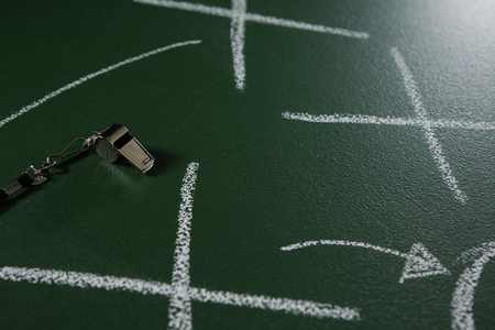 Close-up of referee whistle lying on green board with strategy drawn on itの写真素材