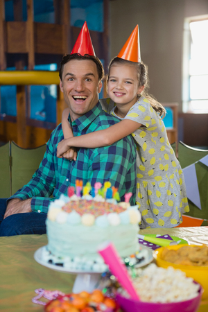Portrait of happy father and daughter celebrating birthday partyの写真素材