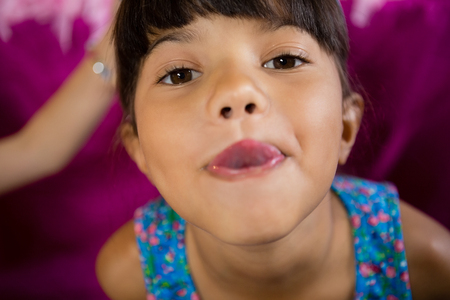 Portrait of girl making funny faces during birthday party at homeの写真素材