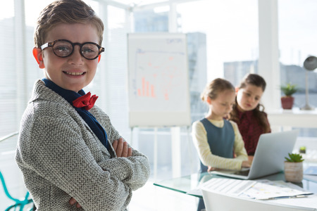 Portrait of confident businessman with female colleagues in background at office