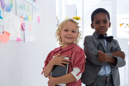 Portrait of smiling business people standing by whiteboard in creative officeの写真素材