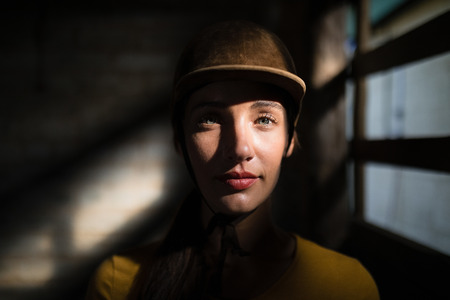 Portrait of confident female jockey in stable