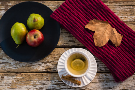 High angle view of lemon tea by fruits in plate on wooden tableの写真素材
