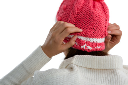 Rear view of woman wearing knit hat against white backgroundの写真素材