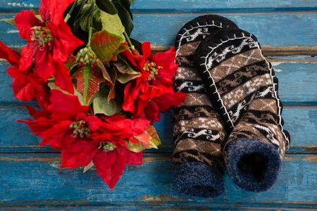 Overhead view of poinsettia by socks on wooden tableの写真素材