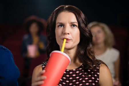 Young woman watching movie in theatreの写真素材