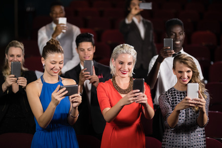 Group of people clicking photographs in movie theatreの写真素材