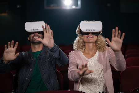 Couple using virtual reality headset in theatreの写真素材
