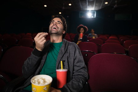 Happy man watching movie in theatreの写真素材