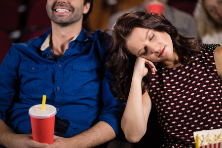 Young woman sleeping in theatreの写真素材
