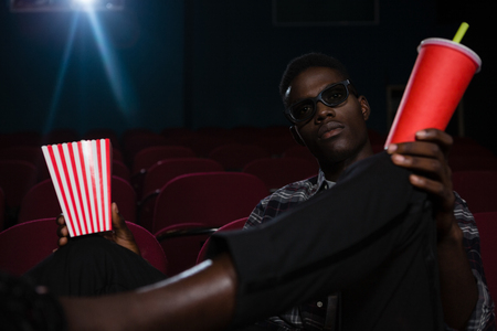 Man in 3d glasses watching movie in theatreの写真素材