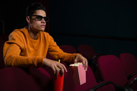 Man in 3d glasses watching movie in theatreの写真素材