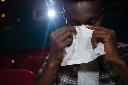 Man getting emotional while watching movie in theatreの写真素材