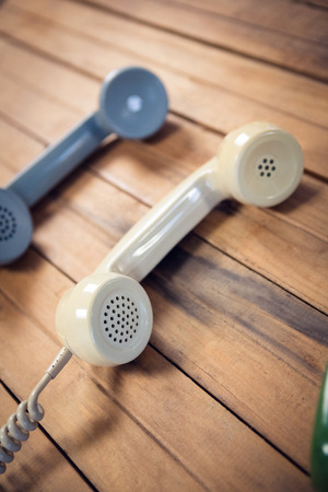 High angle view of telephone receivers on wooden tableの写真素材