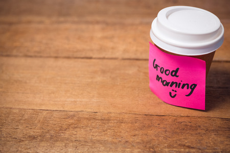 Close up of good morning text stuck on disposable cup at wooden tableの写真素材