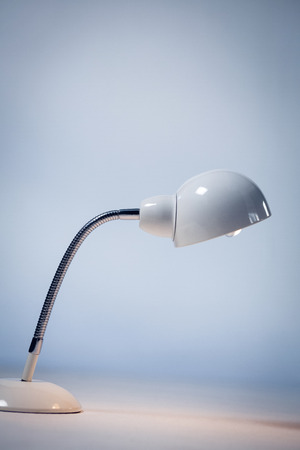 Close up of illuminated electric lamp on table by wallの写真素材