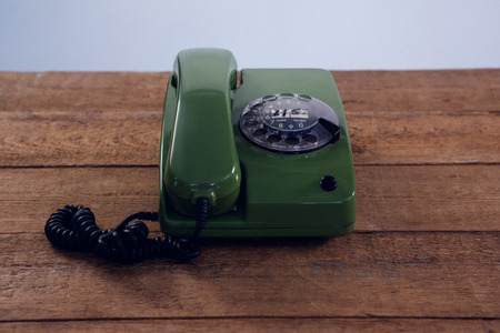 Vintage phone on wooden table against white backgroundの写真素材