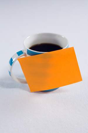 Close-up of black coffee with blank sticky note on white backgroundの写真素材