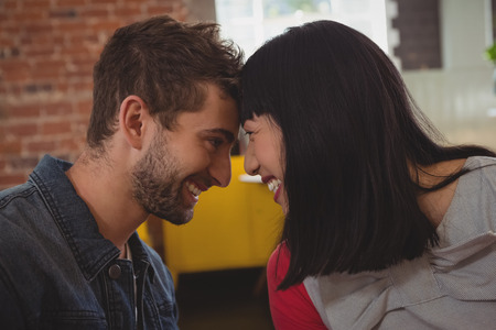 Happy young couple looking each other in cafeの写真素材