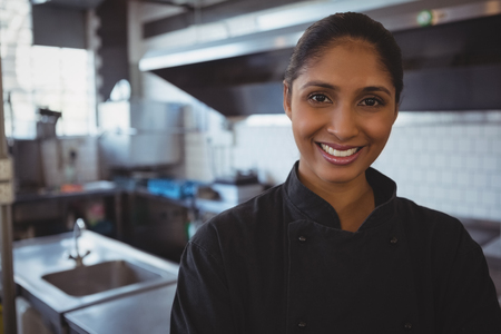 Portrait of happy young waitress standing in cafeの写真素材