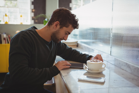 Young man using digital tablet in cafeの写真素材