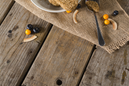 Overhead of granola bar and berry fruit on wooden tableの写真素材