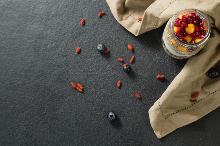 Yogurt with pomegranates and golden berries in glass jarの写真素材