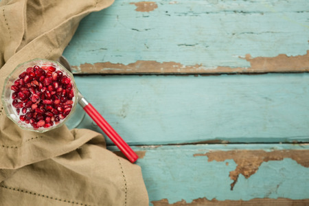 Cup of yogurt with raspberry and pomegranate on wooden tableの写真素材