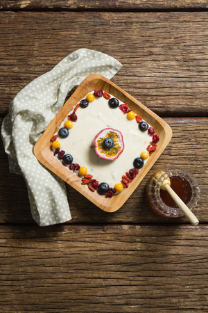Close-up of fruit yogurt and honey on a wooden tableの写真素材