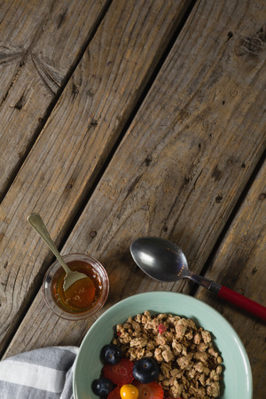 Fruit cereal in jar with napkin cloth on a wooden tableの写真素材