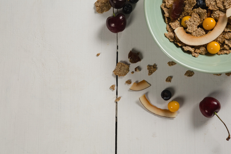 Bowl of wheat flakes with blueberry and golden berry on tableの写真素材